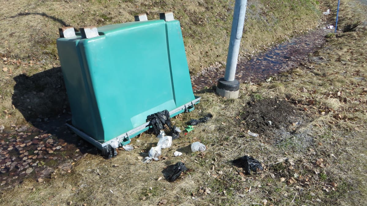 Kaadettu roska-astia ja roskia maassa.