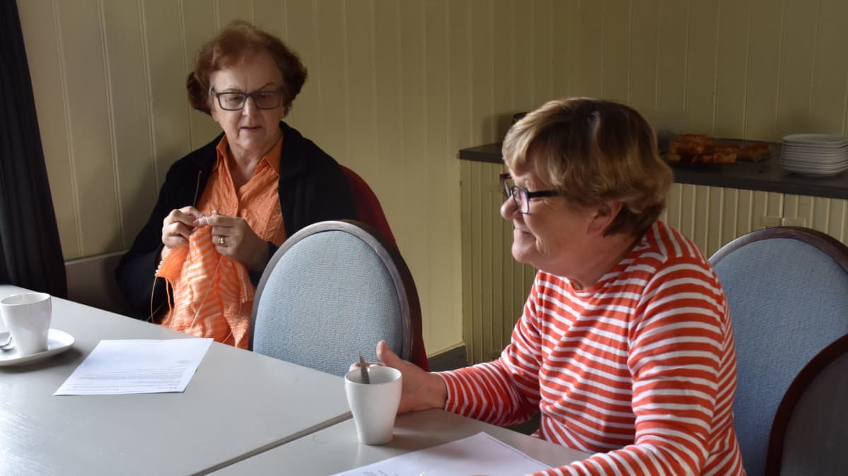 Aila Ranta ja Tuija Norrlund istuvat kahvipöydässä.