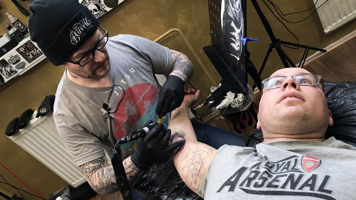 Miestä tatuoidaan.