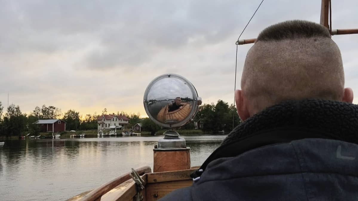 Kuvassa mies ajaa veneellä