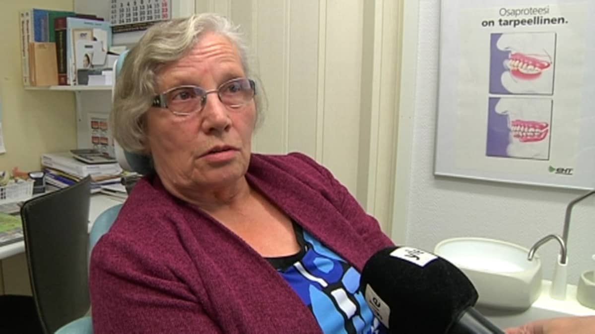 nainen istuu hammaslääkärin tuolissa