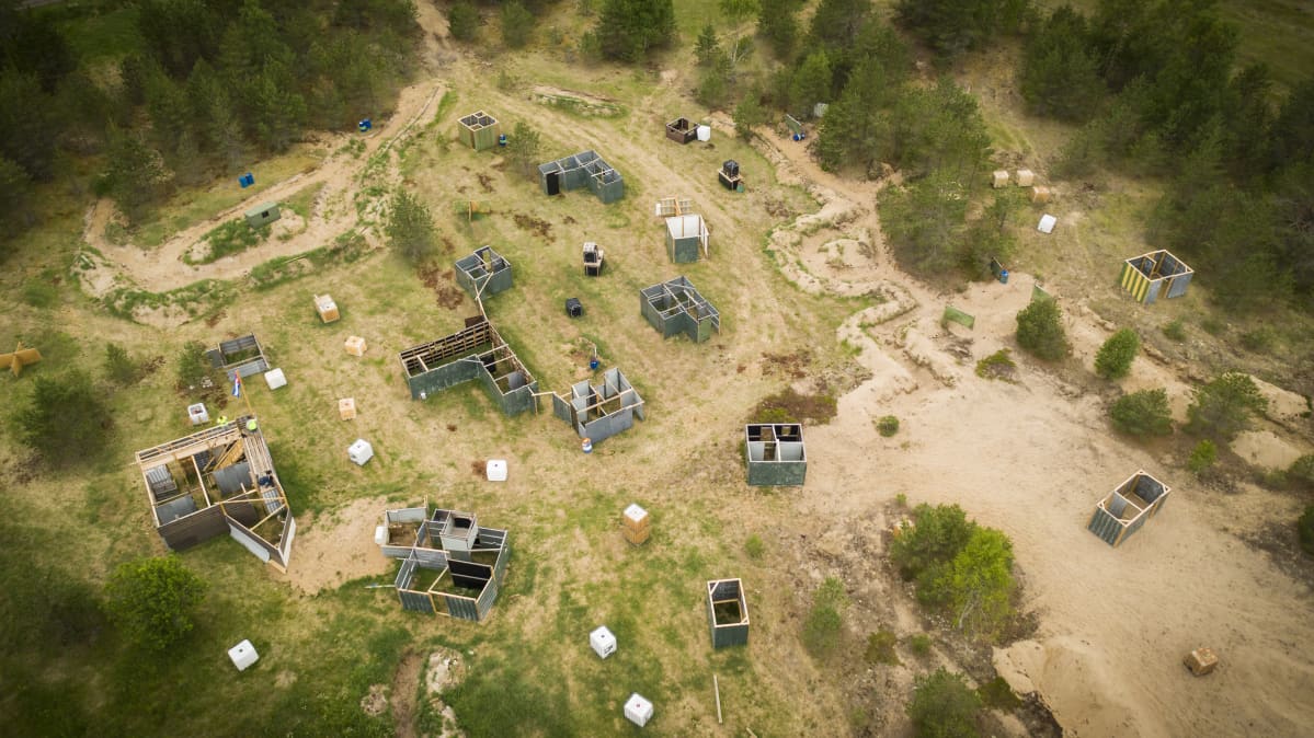 Airsoft-rata kuvattuna ilmasta. Paljon rakennuksia rakennettuna metsän keskellä sijaitsevalle aukiolle.