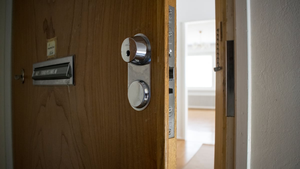 Kerrostalohuoneiston ovi raollaan rappukäytävässä