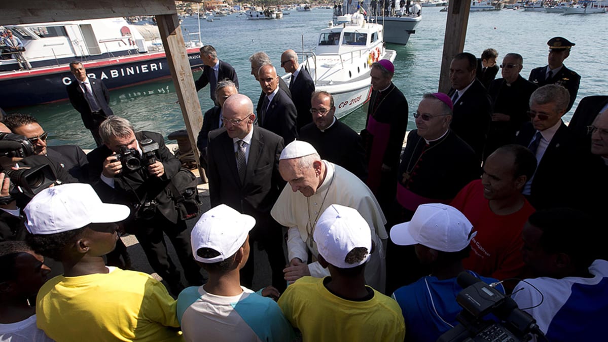 Paavi Franciscus tervehtii siirtolaisia vieraillessaan Lampedusan saarella.