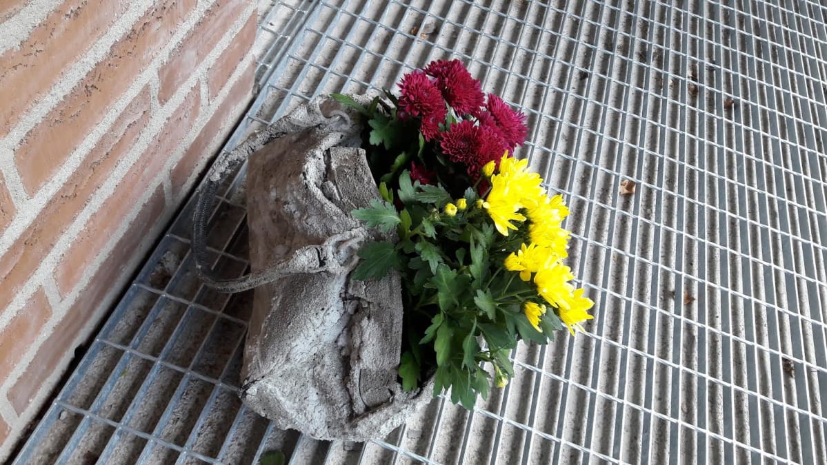 Kynnystien palvelukodin ovella betonoitu laukku.