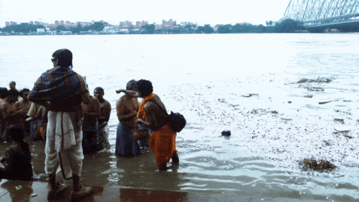 Mies heittää roskapussin Ganges-jokeen.