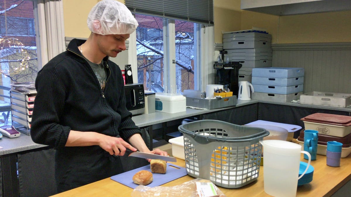 Toimitilahuoltaja Antti Bäck leikkaa leipää päiväkodin keittiössä