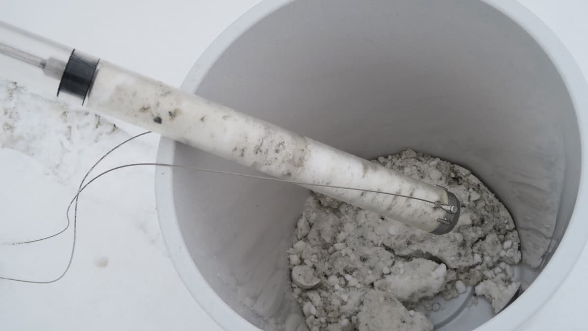 Likaista lunta muoviämpärissä laboratoriotutkimusta varten