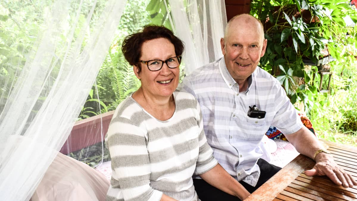 Tuire Kettunen ja Erkki Valkola istuvat huvimajassa omassa puutarhassaan