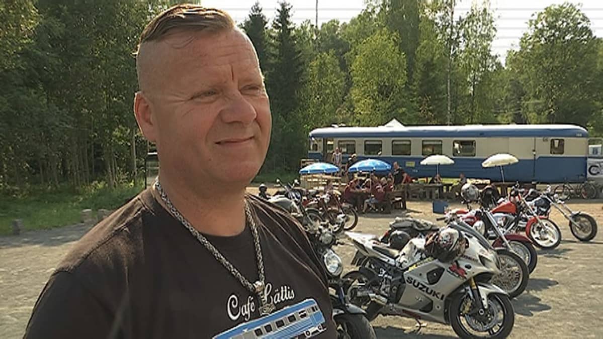 Jaakko Hämäläinen, taustalla moottoripyöriä ja lättahattukahvila