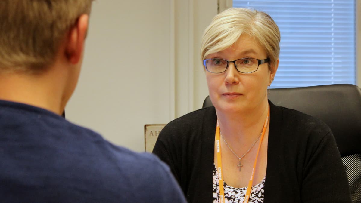 Koulupsyykkari ja oppilas istuvat vastakkain.