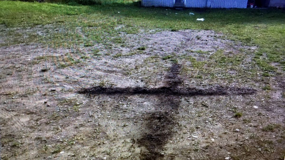 Hietikolla näkyy maahan poltettu musta risti.