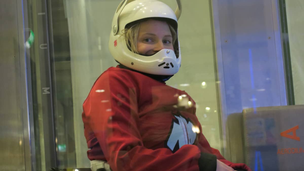Ratakelaaja Amanda Kotaja kypärä päässään tuulitunnelin vieressä.