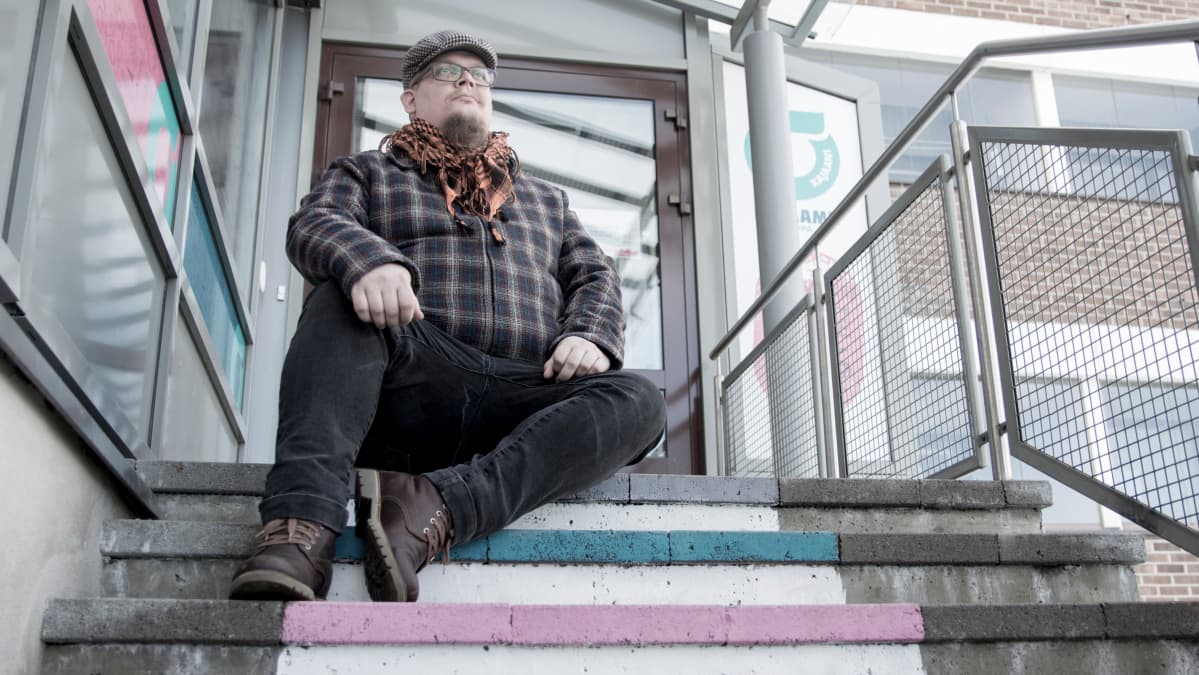 Markku Korhonen istuu portailla