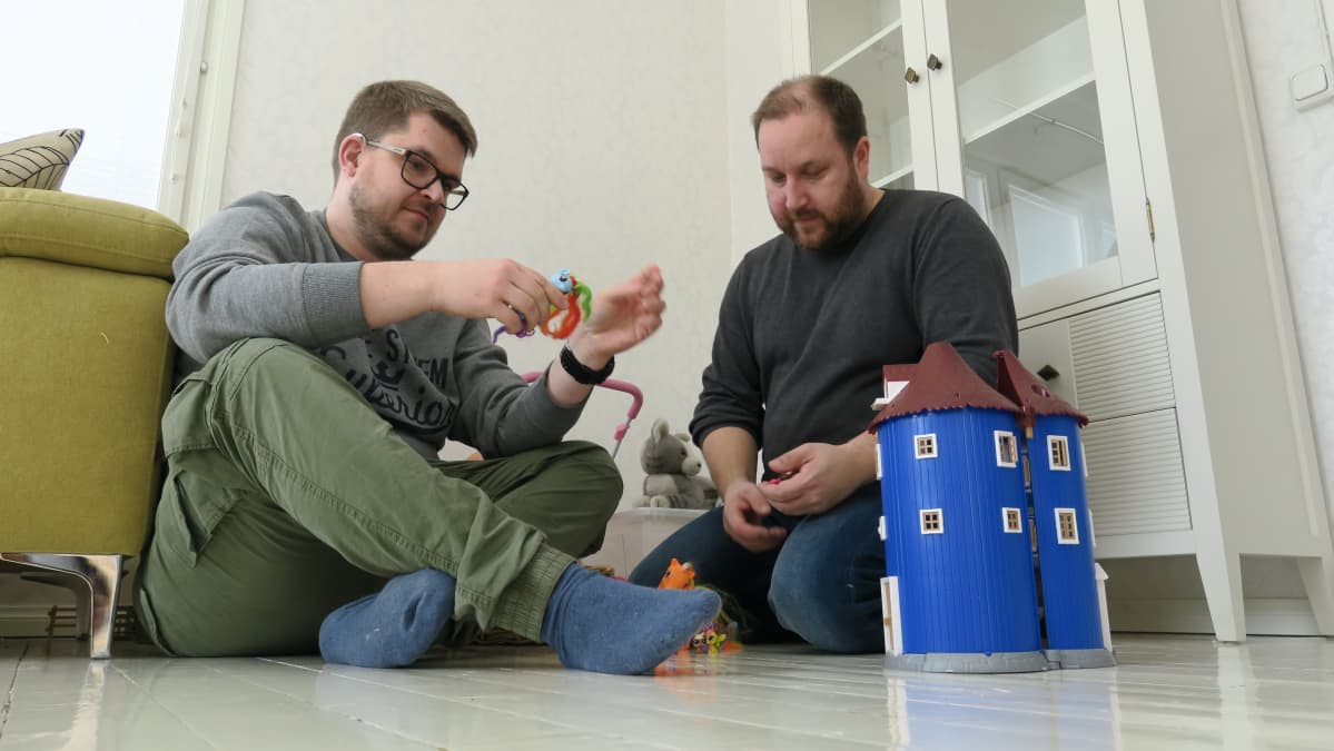 Kaksi miestä lasten lelujen keskellä