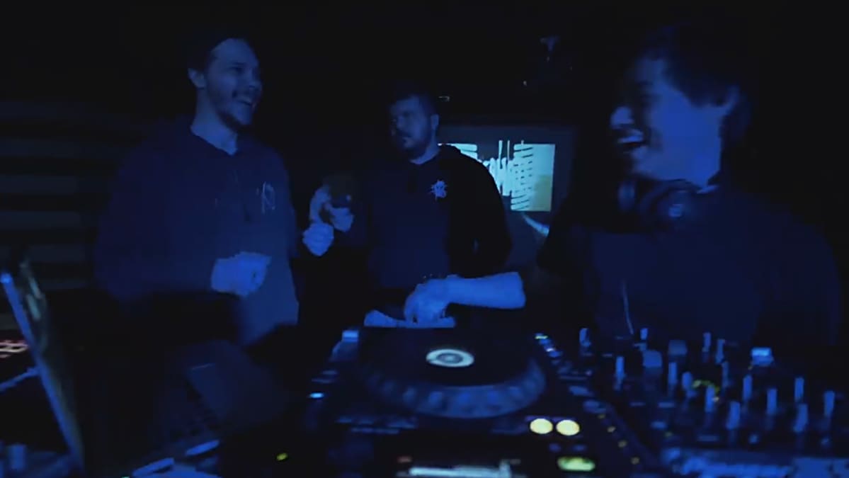 Naurava nuoriso dj-pöydän takana.
