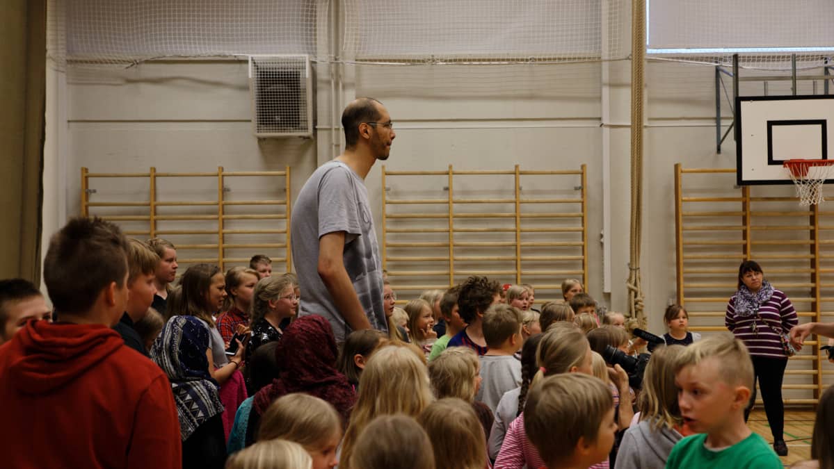 Brahim Takioullah seisoo lasten keskellä.