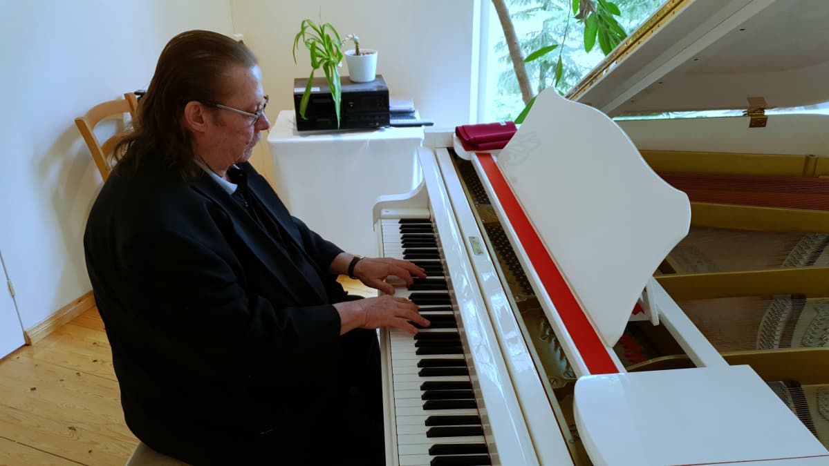 Kassu Halonen soittaa valkoista flyygeliä.