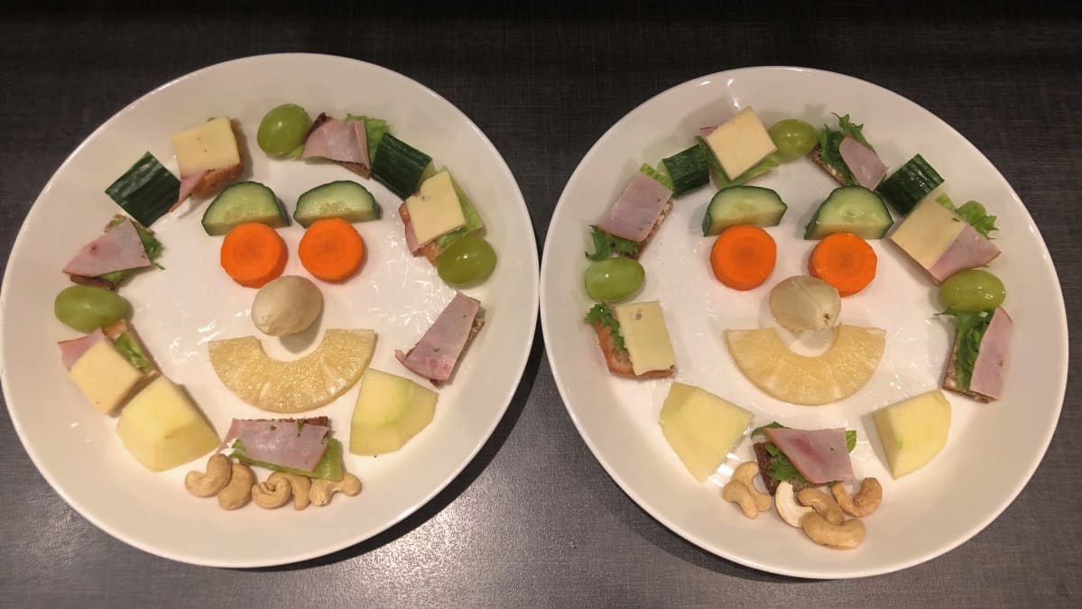 Välipala lautasella naaman muotoon aseteltuna