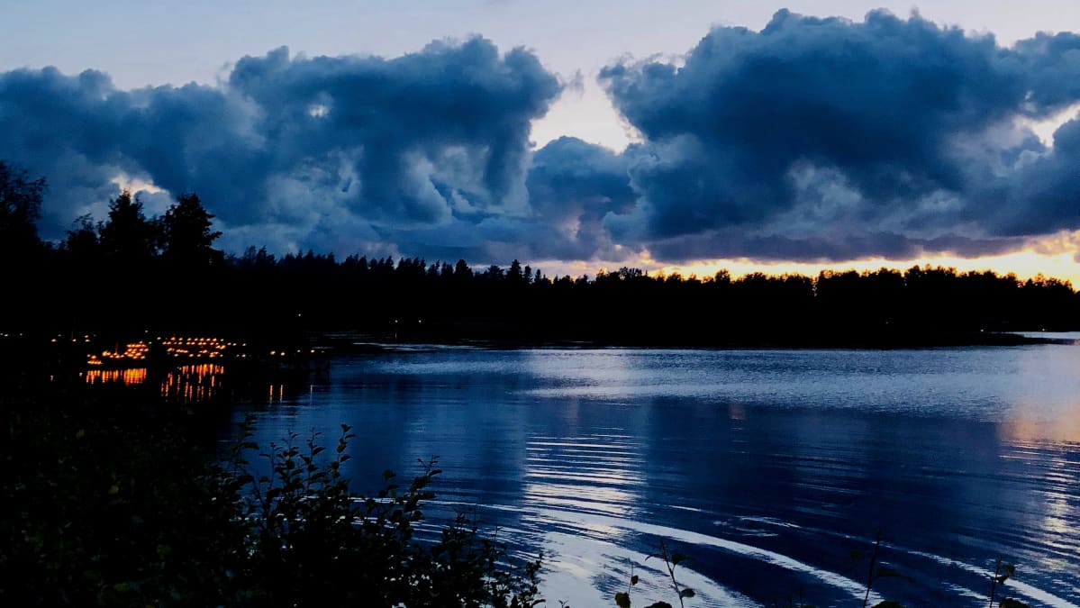 Kuvassa merenrantaa ja kynttilöitä hämärällä