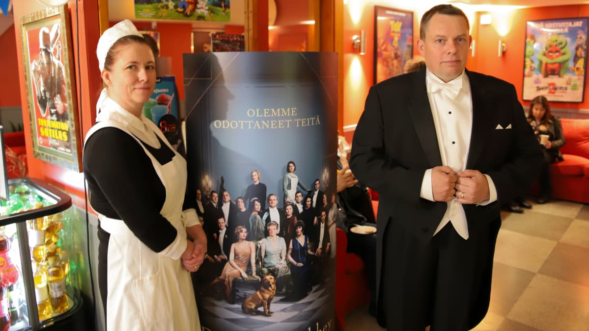 Johanna- ja Juha Åman poseeraa mainoksen edessä
