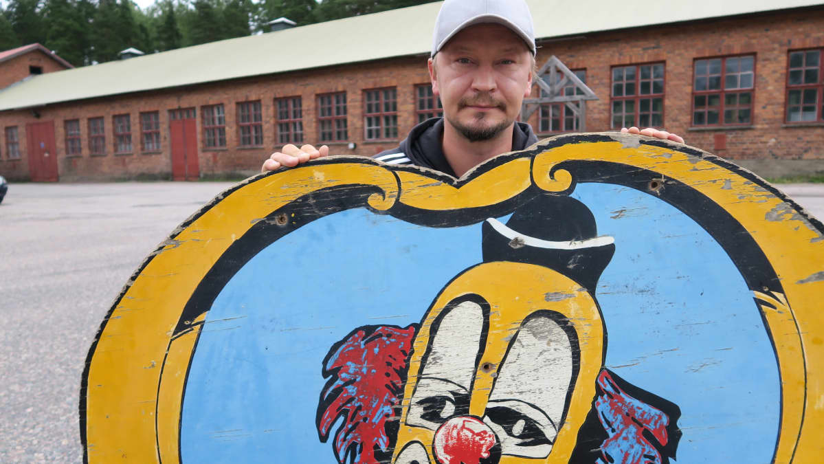 Carl Jernström junior esittelee roskalavalta pelastettua pellekylttiä tulevan Sirkusmuseon pihalla.