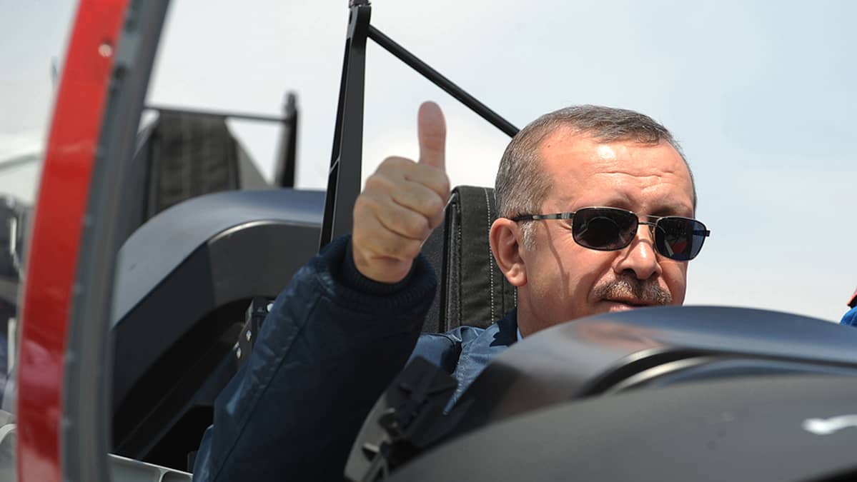 Turkin pääministeri Recep Tayyip Erdogan poseeraa kuvaajille Turkin ensimmäisen itse valmistaman harjoitushävittäjän Hurkusin esittelytilaisuudessa.