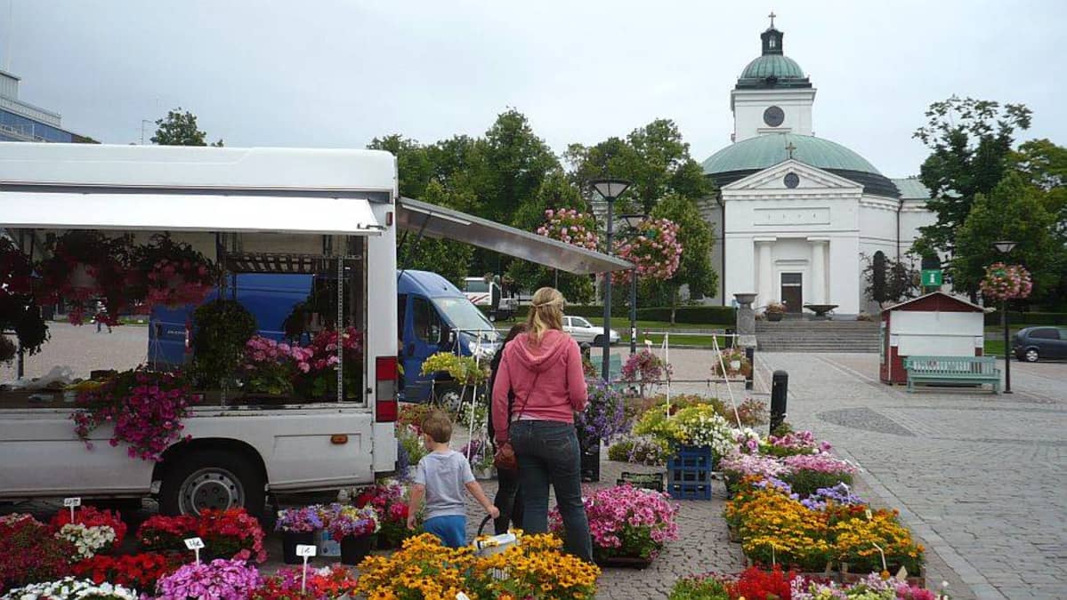 Kukkienmyyjä Hämeenlinnan torilla, taustalla kirkko