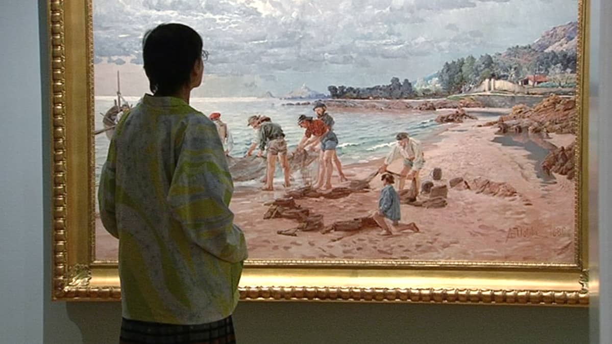 Näyttelyvieras katselemassa August Uotilan maalausta Amos Andersonin taidemuseossa.