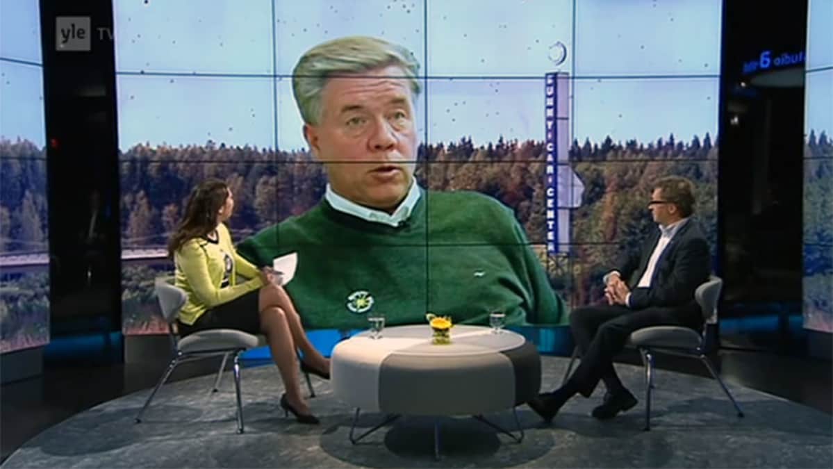 A-Studiossa Annukka Roininen ja Juha Isosuo, taustalla kuvassa Markku Ritaluoma