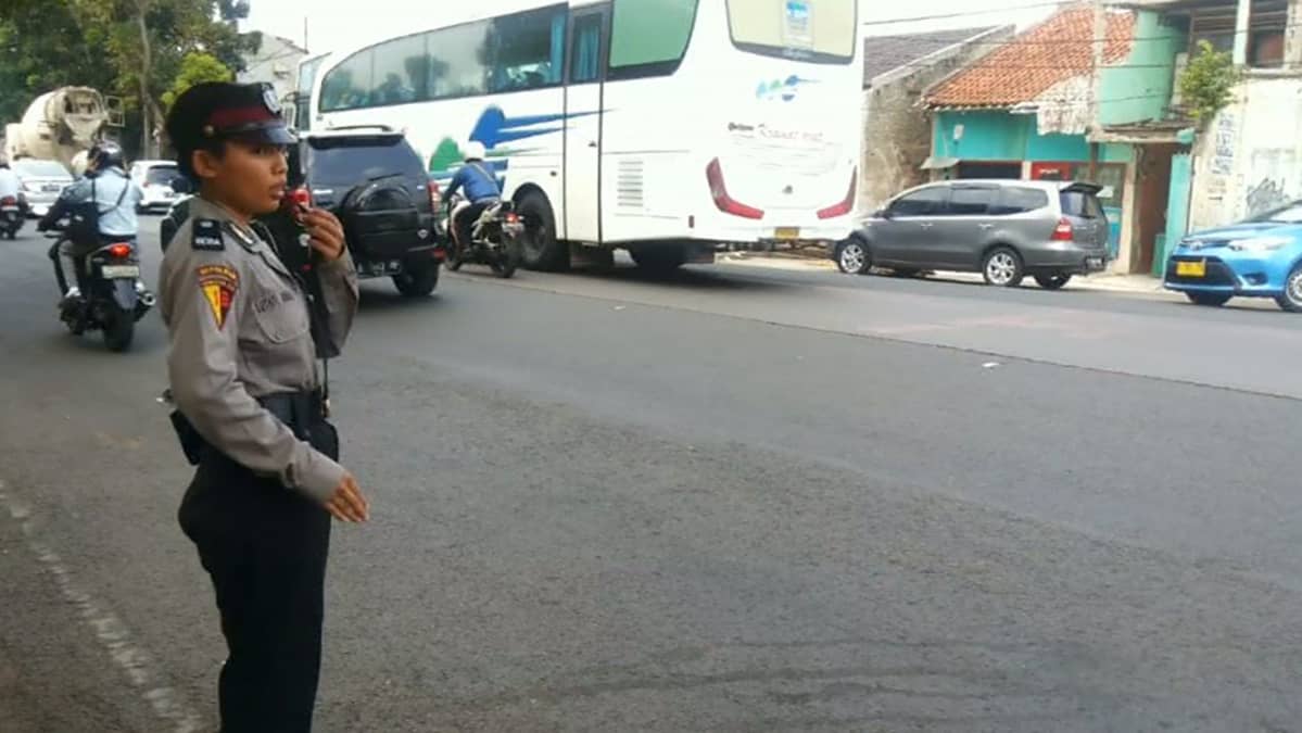 Naispoliisi ohjaamassa liikennettä Indonesian pääkaupungissa Jakartassa.
