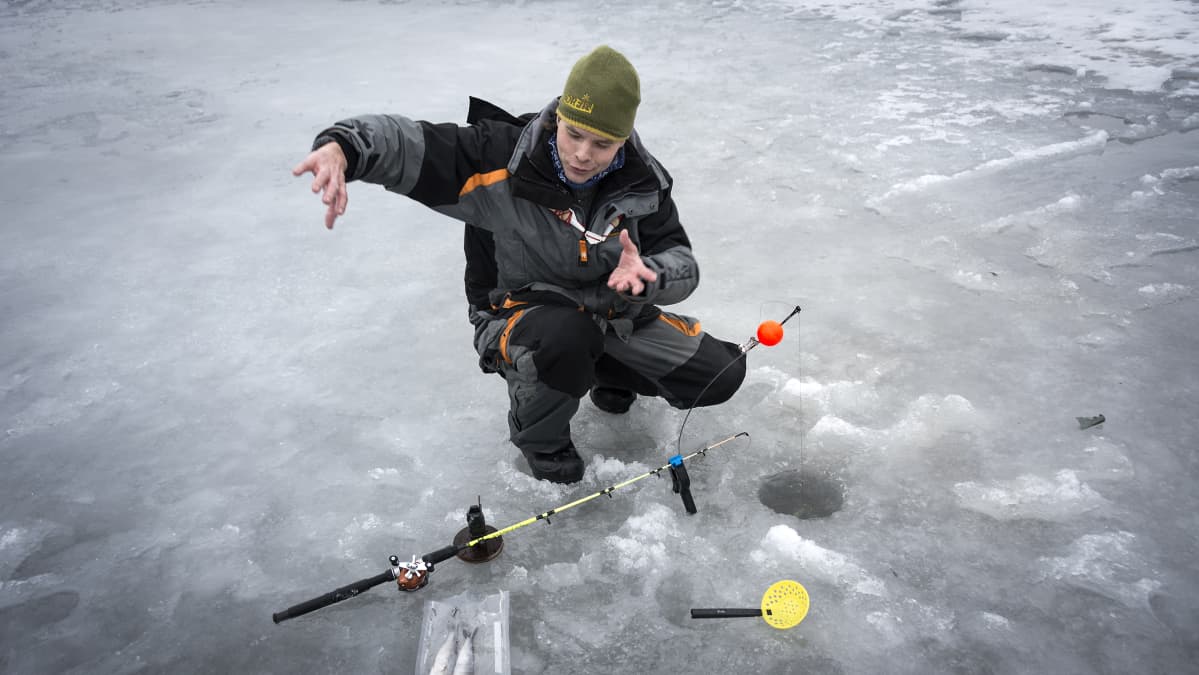 Kalastusopas Markus Sallinen esittelee ismete-kalastusta järven jäällä.
