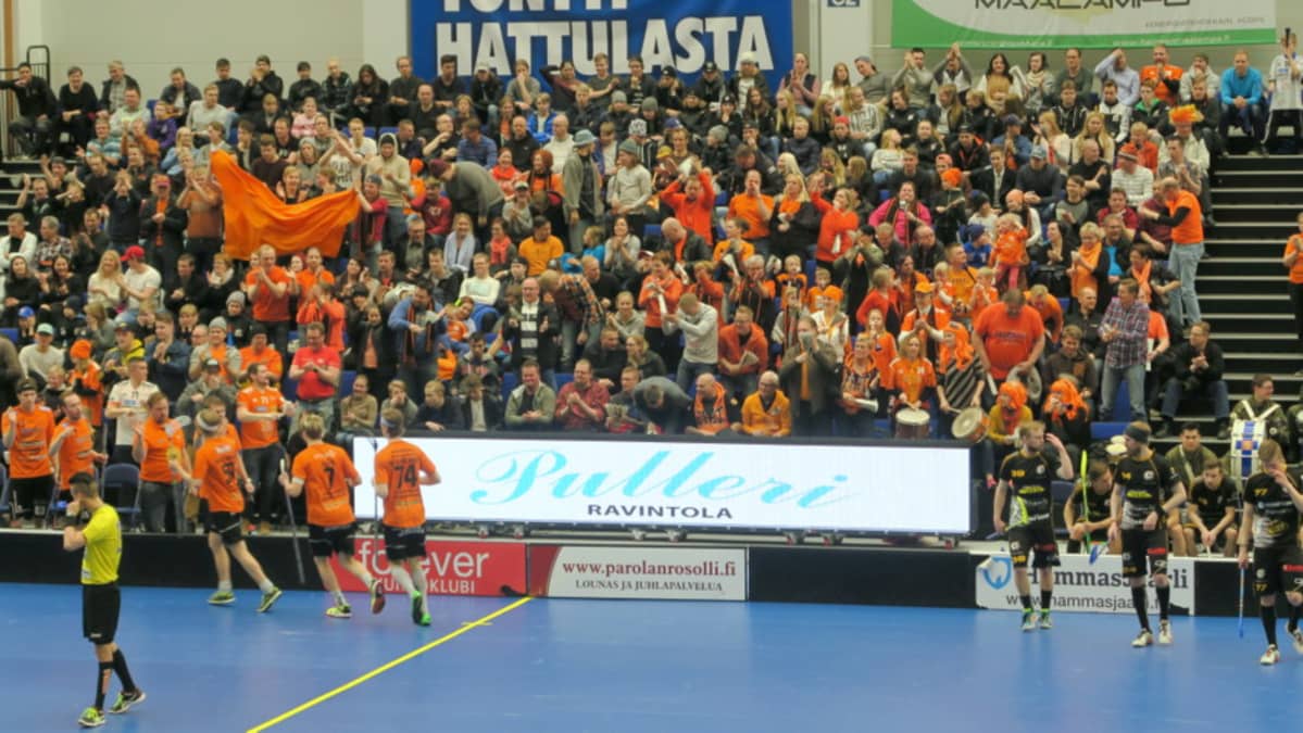 Yleisöä salibandykatsomossa, oranssissa Lammin Salibandyn kannattajia