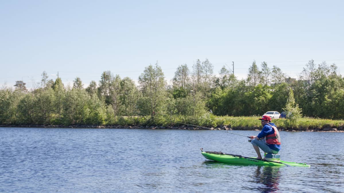 Suppausyrittäjä Jyrki Vahlamo kalastaa SUP-laudan päältä.