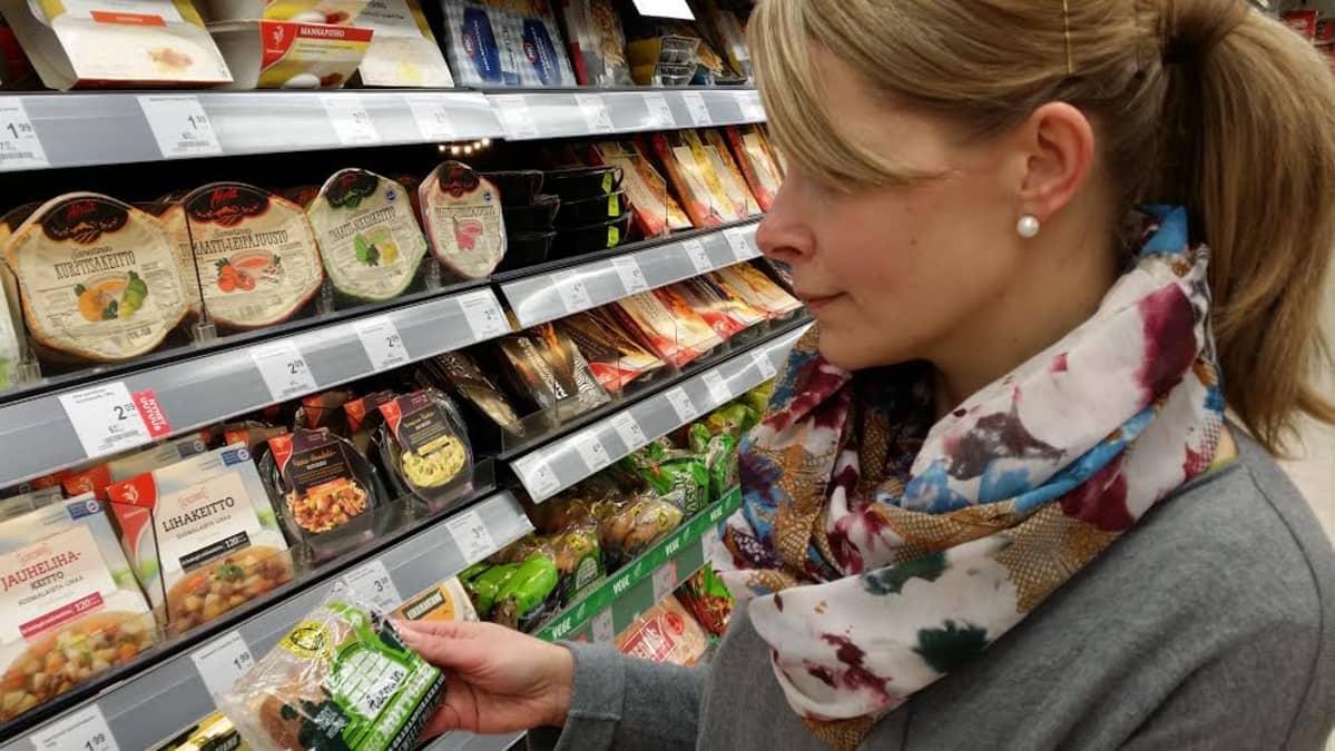 Johanna Mattila tutkii kasvistuotteita ruokahyllyllä.
