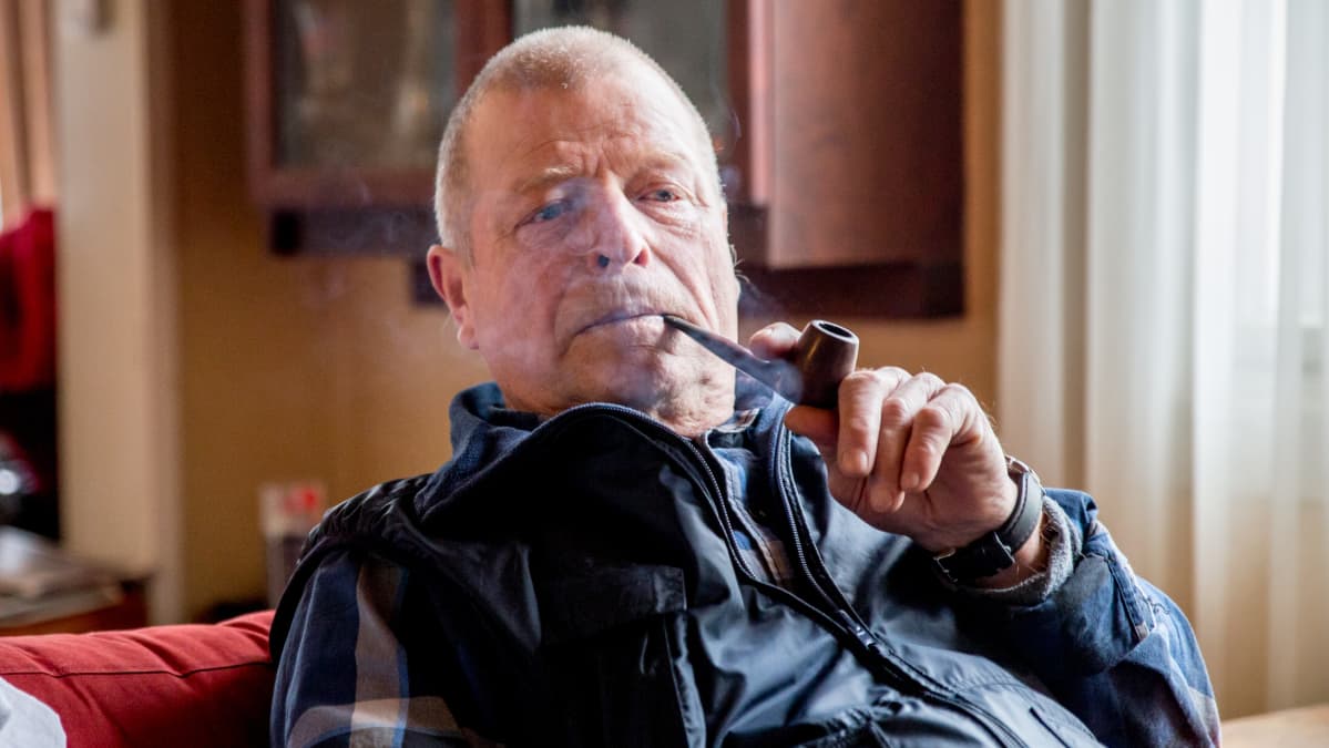 Kalle Reponen polttaa piippua nojatuolissa