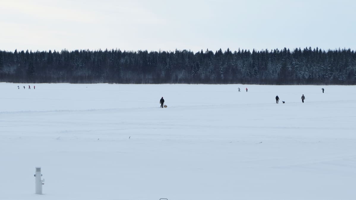 Ihmisiä ulkoilemassa meren jäällä.