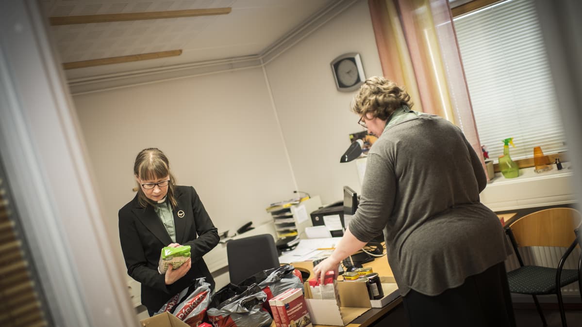 Pietarsaaren suomalaisen seurakunnan diakonit Kirsi Rundgren ja Petra Karvinen täyttävät ruoka-apukasseja.