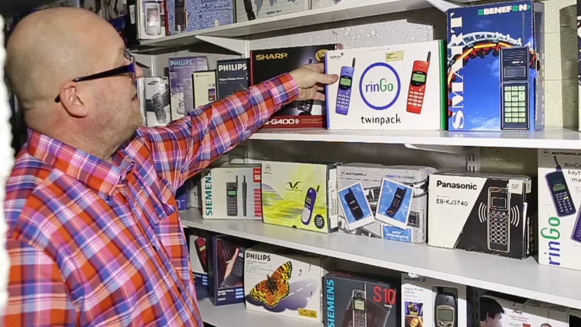 Mika Ollila esittelee matkapuhelinpakkauksia