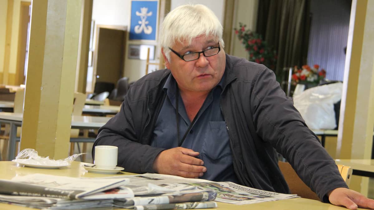 Paavo Pulli lukee lehteä sotilaskodissa
