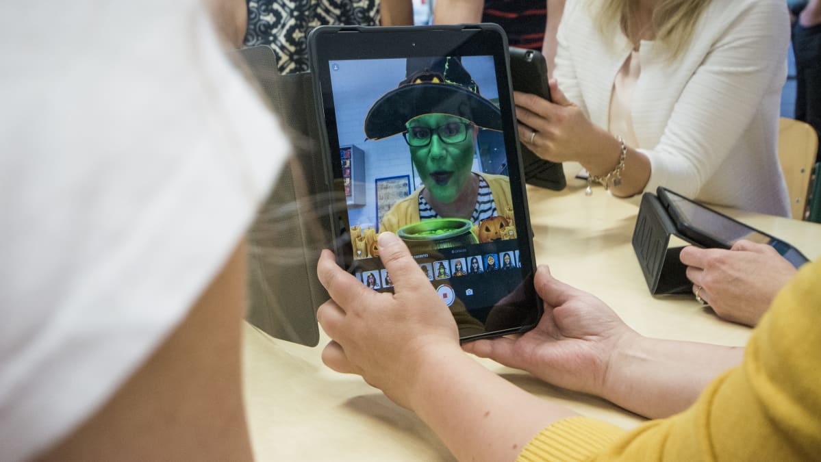 Opettaja ottaa tabletilla kuvaa.