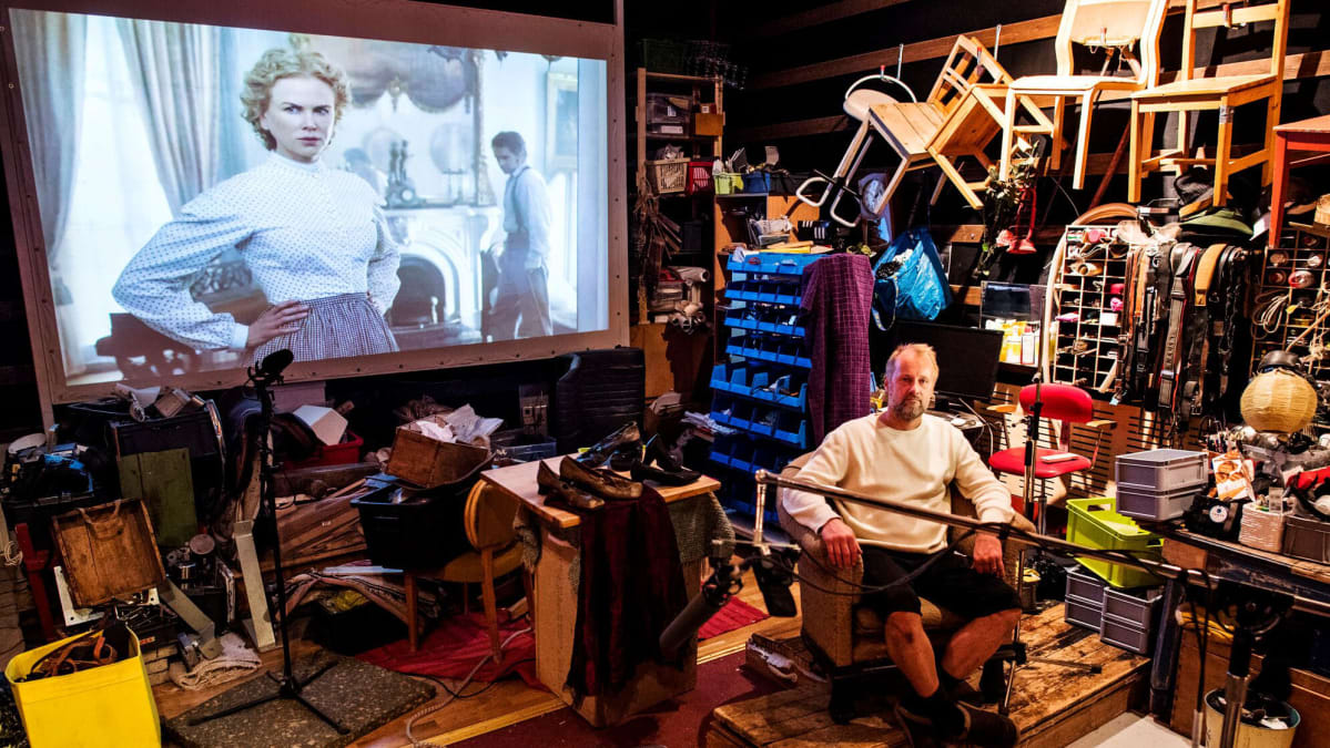 Heikki Kossi studiollaan, taustalla Nicole Kidman valkokankaalla elokuvassa Lumotut.
