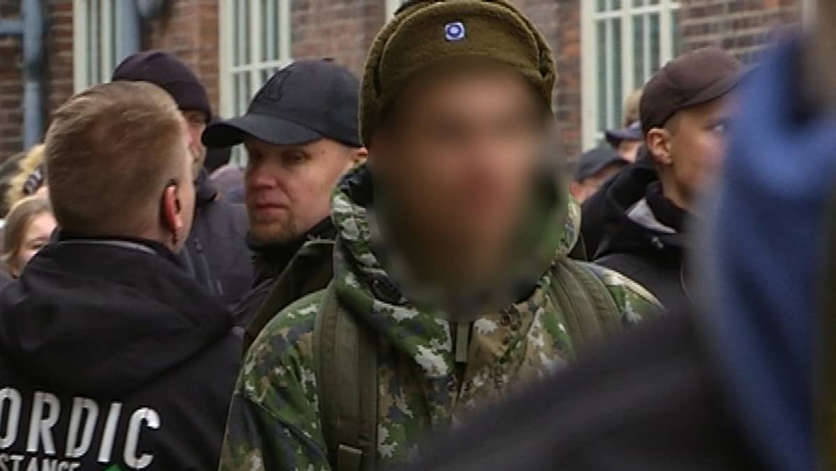 Sotilaspukuinen varusmies mielenosoittajien joukossa