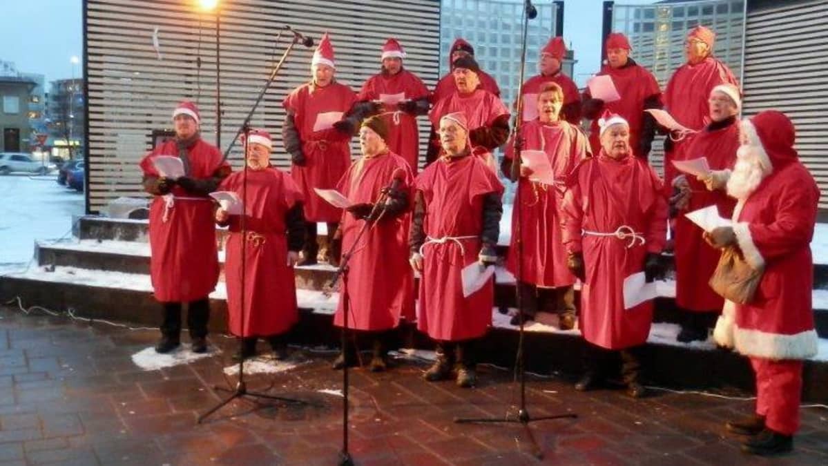 miehiä laulamassa tonttuasuissaan
