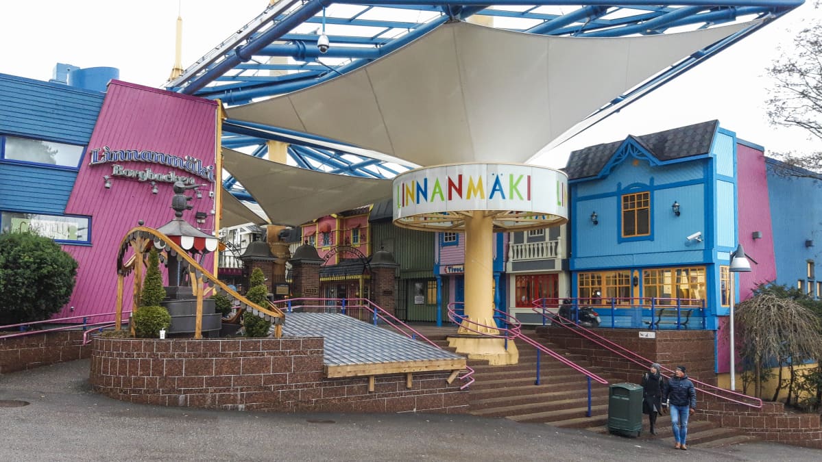 En ingång till en nöjespark. På väggen och på en skylt står det "Linnanmäki" och "Borgbacken".