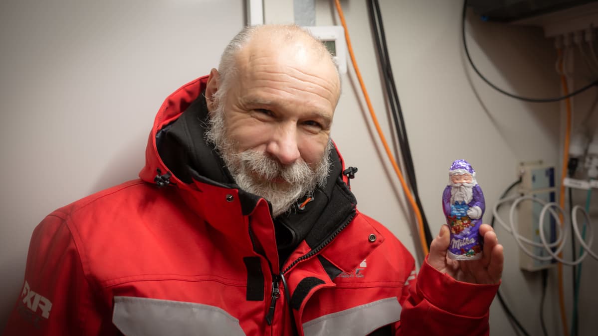 Hymyilevä partainen Jari Haapala pitelee kädessään suklaista joulupukkia.