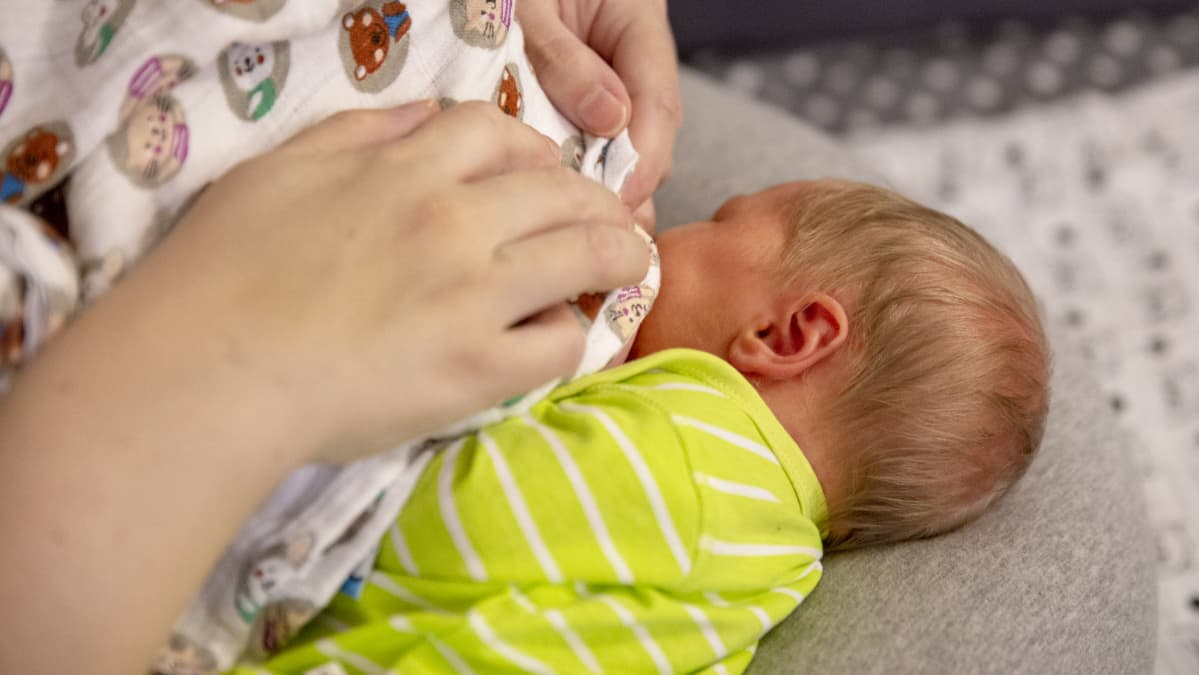 5 päivän ikäinen tyttö imee rintaa imetystyynyn päällä.