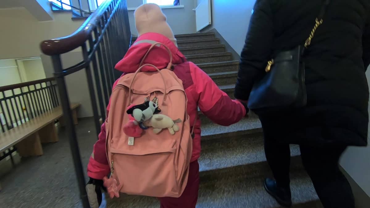 Lapsi ja äiti nousevat koulun rappusia.
