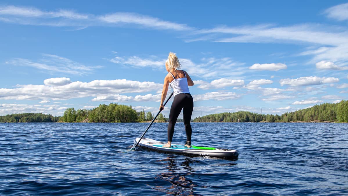 Tiia Vepsäläinen sup-lautailee Saimaalla Lappeenrannan Myllysaaren rannassa.