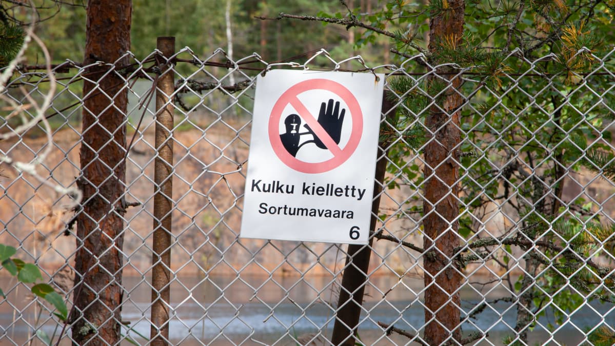 Telkkälän vanhan avolouhoksen turva-aidassa kyltti "Kulku kielletty Sortumavaara".